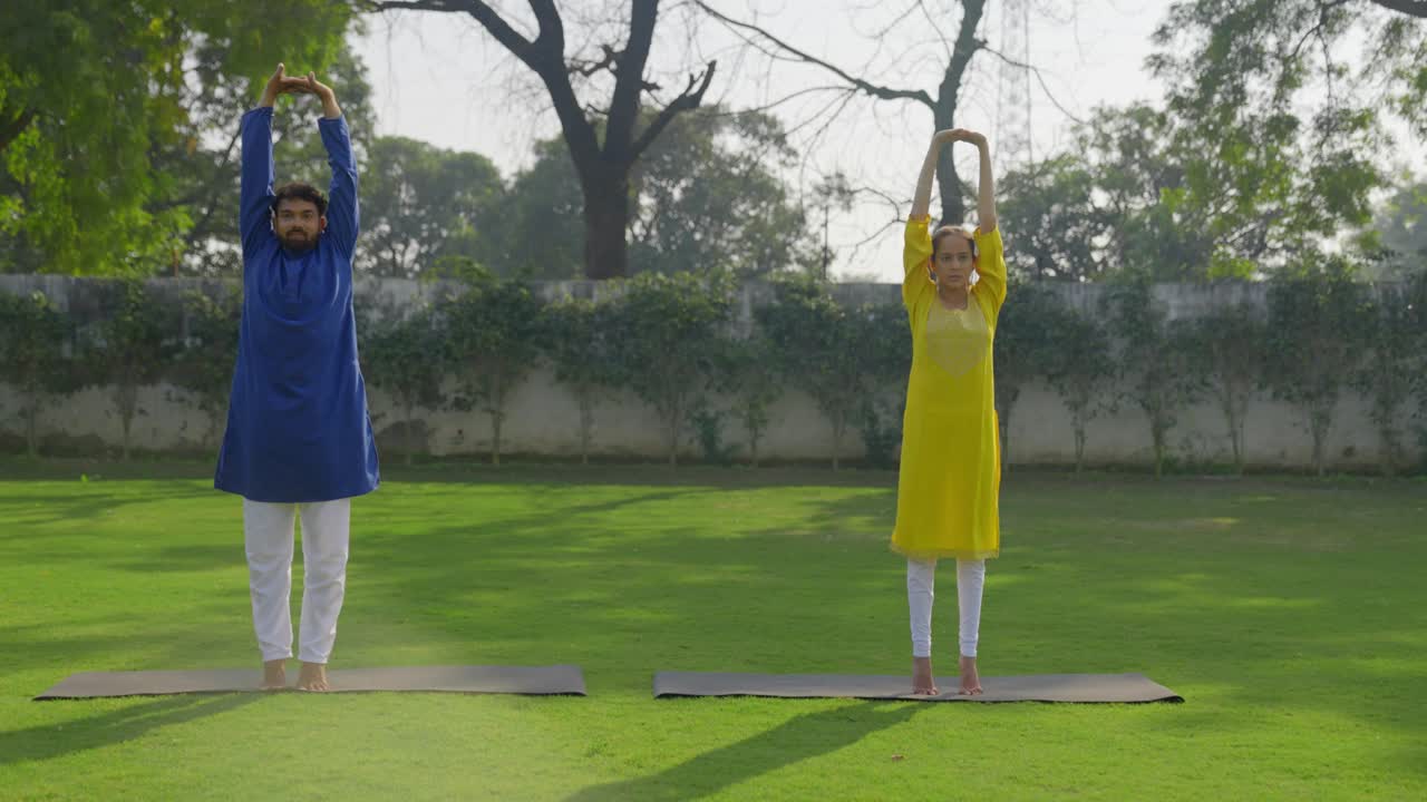 공원에서 아침에 전체 신체 운동을 하는 인도인 부부