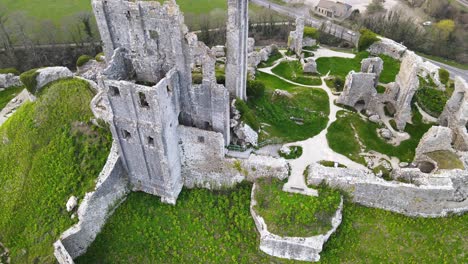 Aerial-top-down-ascendent-over-Corfe-Castle-ruins-in-County-Dorset,-England