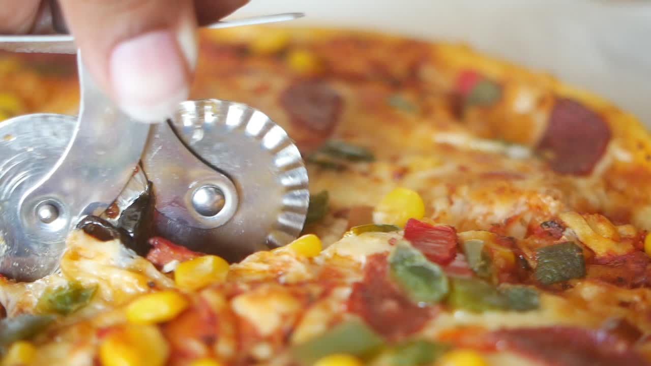 피자 커터로 잘라내는 피자의 클로즈업