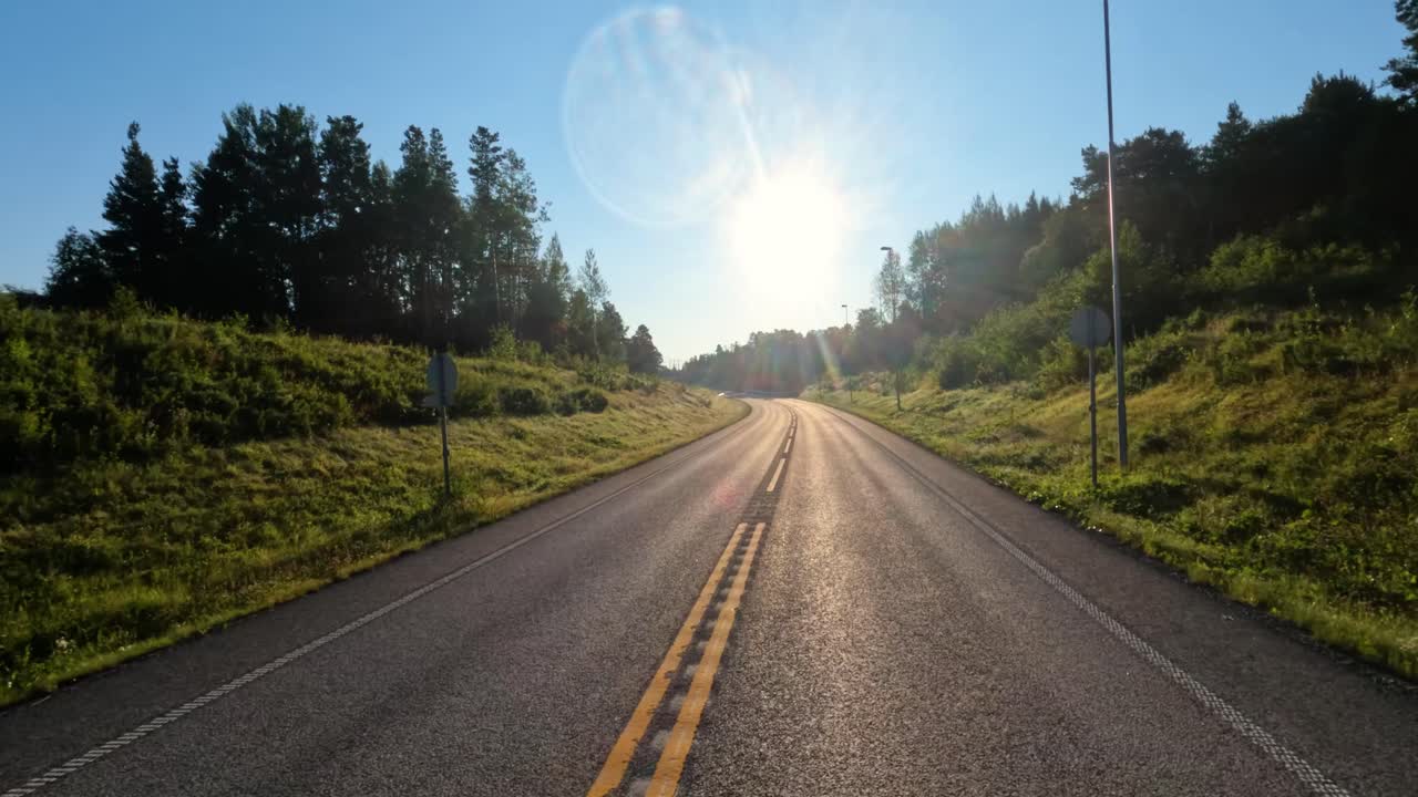 conduciendo un coche en una carretera de noruega al amanecer.