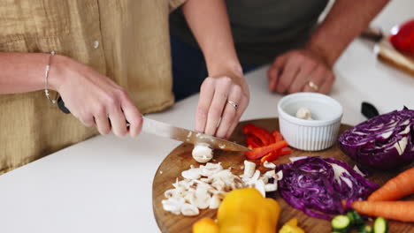 manos, cuchillo y verduras para la pareja en el hogar