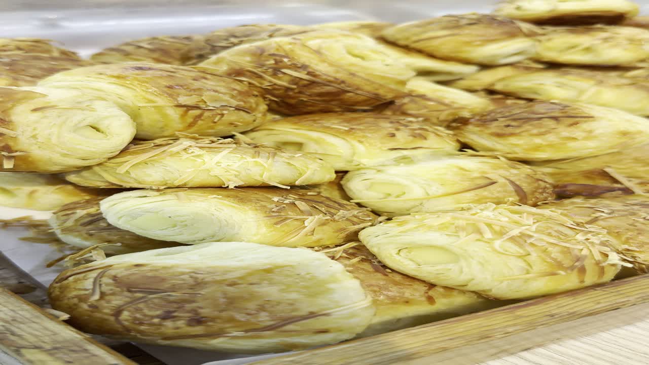 Primo piano di cornetti al formaggio appena sfornati in una vetrina di panetteria