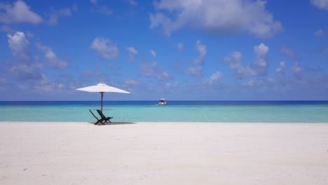 Isolated-sun-chairs-on-bright-white-caribbean-beach-by-crystal-clear-water