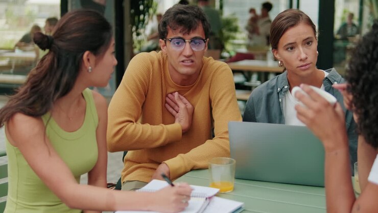 Close up of a diverse group of students having a lively conversation and using