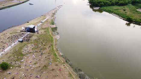 Multitud-De-Personas-En-El-Escenario-Musical-En-La-Conjunción-Del-Río-Nemunas-Y-Neris,-Vista-Aérea-Sobrevolando