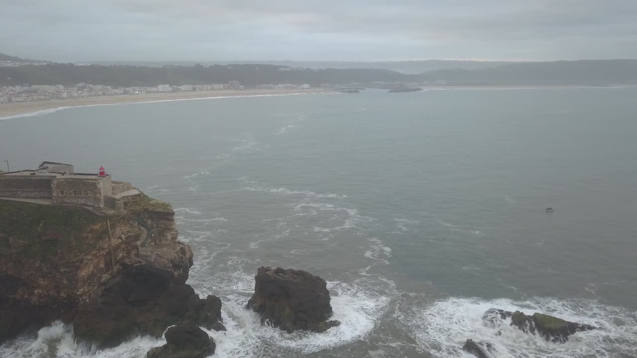 знаковое место на побережье атлантики, мекка серфинга на больших волнах. вид маяка назаре в северном каньоне, место с самыми большими волнами в европе, назаре, португалия