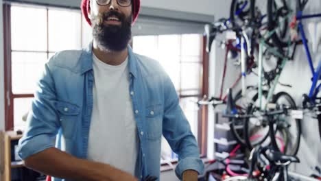 Mechanic-repairing-bicycle-in-workshop