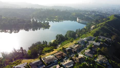 stunning birds-eye-view over the hollywood reservoir. bright morning with the sun's reflection on the water. gliding shot