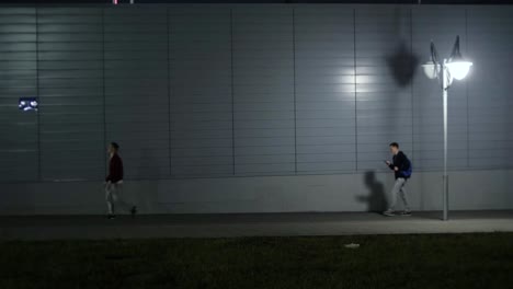 people walking at night on a city street