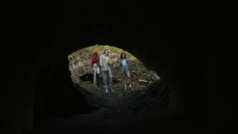 friends exploring an abandoned tunnel