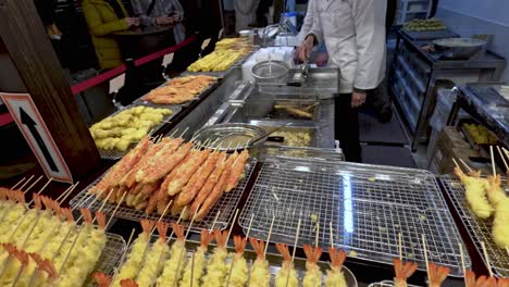 vendor cooking tempura skewers at street food stall