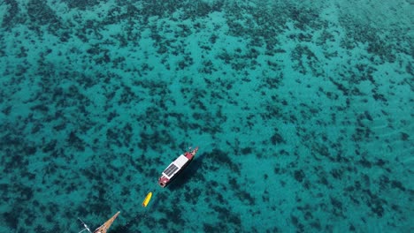 Birds-Eye-Aerial-View,-Boat-With-Solar-Panels-and-Blue-Tropical-Sea-Water-by-Komodo-Island,-Indonesia