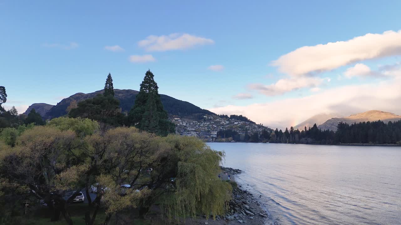 Aerial footage captures Queenstown's serene lake, lush greenery, and majestic mountains under soft, natural lighting