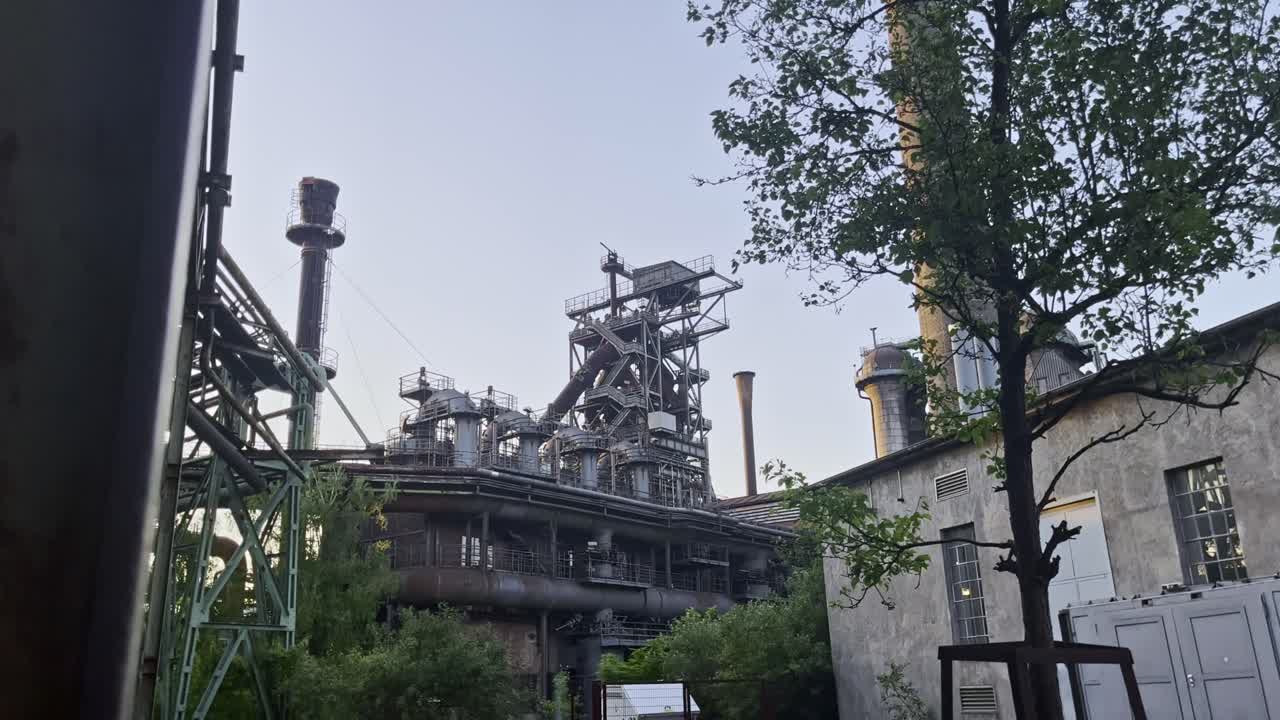 Industrial complex in the landscape park in duisburg, germany steel blast furnace with tree in the foreground
