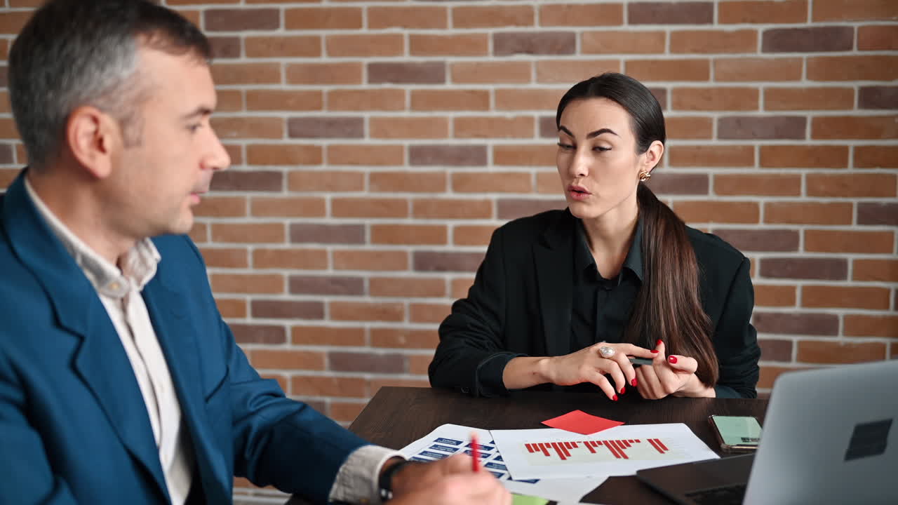 Coworkers talking at a table in an office