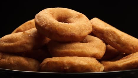 close up: the pile of a doughnuts rotation on a black background