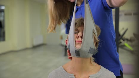 woman undergoing cervical traction therapy with assistance