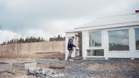 un hombre entrando en el invernadero con ventanas de vidrio