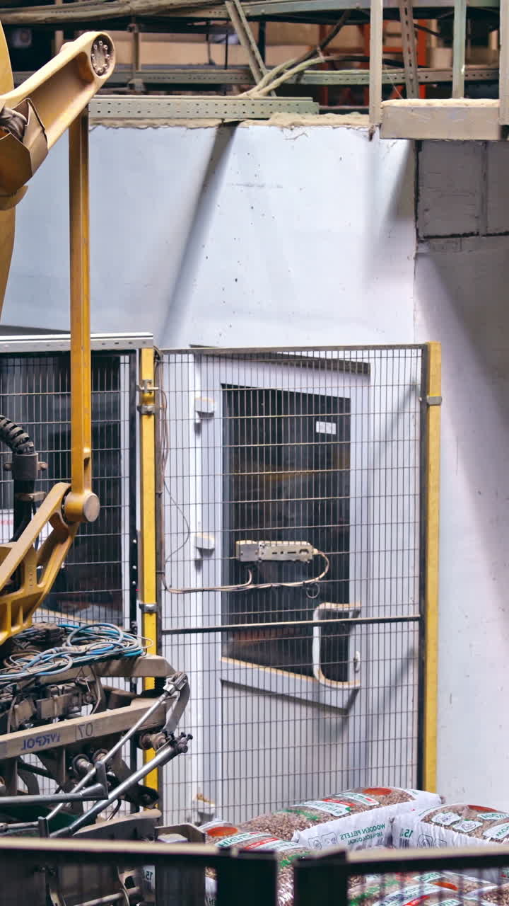 Mechanical robot with artificial intelligence sorts bags on the conveyor. Putting bags from line to the pallet. Process closeup. Vertical video