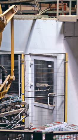 mechanical robot with artificial intelligence sorts bags on the conveyor. putting bags from line to the pallet. process closeup. vertical video