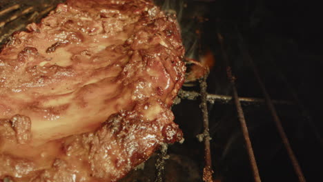 close up of flames underneath a slab of spareribs being grilled on a barbecue