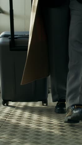 person walking with luggage through an airport or train station