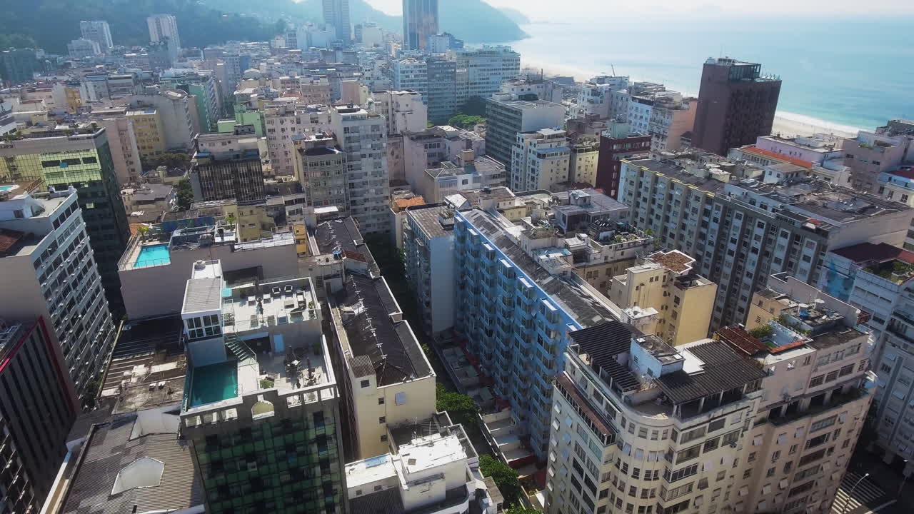 Drone avança sobre o horizonte do Rio, inclinando-se para as ruas.