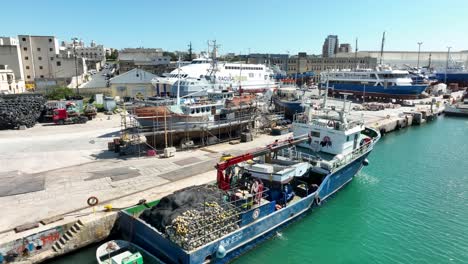 drone aerial shot over rising over ships in a boat yard while panning down and revealing a top point of view