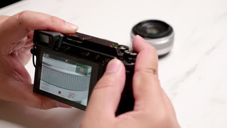 male hand using camera to take photos of items on white background to sell in online market