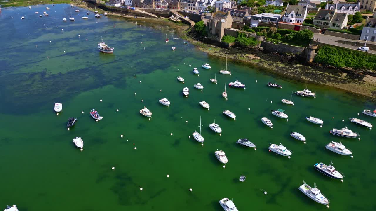 Panning drone movement over the Vieux Port du Conquet marina with floated boats and yachts near coastal commune properties, Le Conquet, Brittany, France.