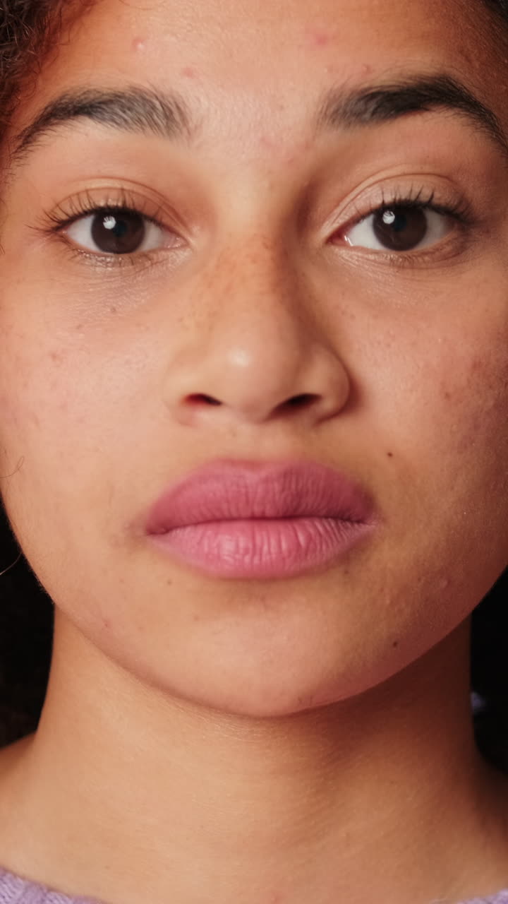 Close-up of Young Woman with Freckles Looking Directly at Camera