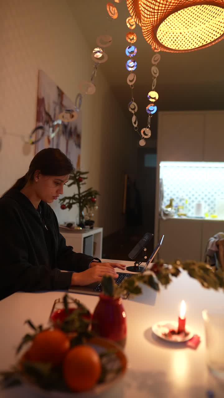 Donna che lavora al laptop a casa durante le vacanze invernali