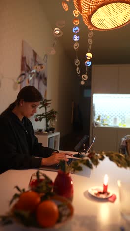 mujer trabajando en una computadora portátil en casa durante las vacaciones de invierno