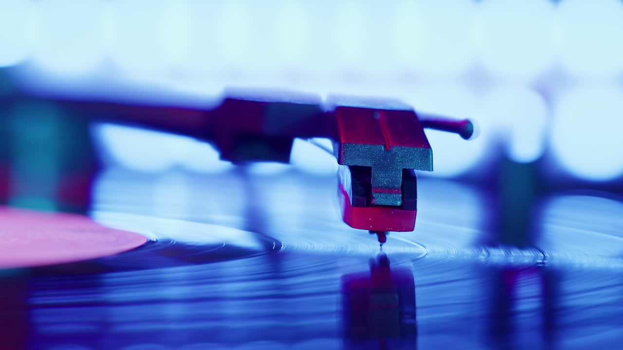 Puntina del giradischi che riproduce un disco in vinile con vivaci luci al neon