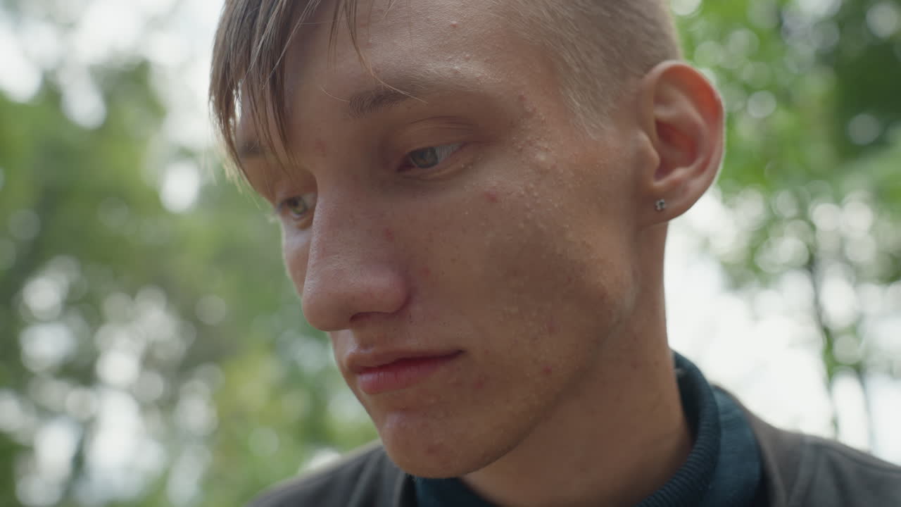 intimate outdoor forest portrait man sweaty skin subtle earring pensive gaze eyes shifting between camera and distance rehearsing monologue in natural light quiet tension cinematic shallow depth raw