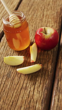 video vertical de primer plano de un frasco de miel y manzanas