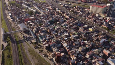 sobrevuelo aéreo barrio pobre rodeado de vías férreas y carretera en buneos aires