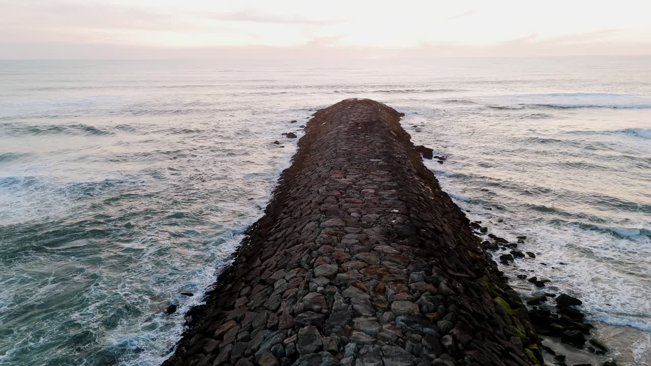 rock stone deck extends into ocean at são pedro de maceda beach in ovar portugal