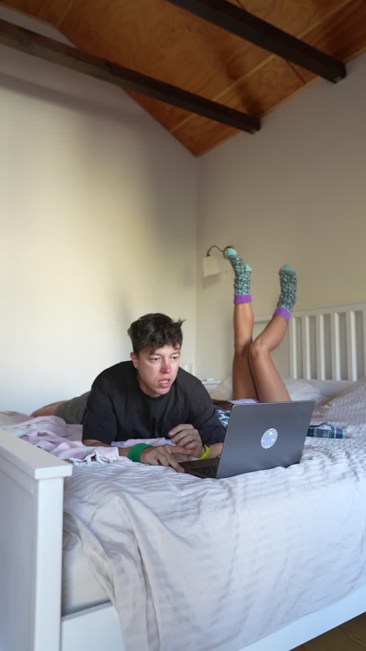 Coppia che si rilassa e lavora al laptop a letto