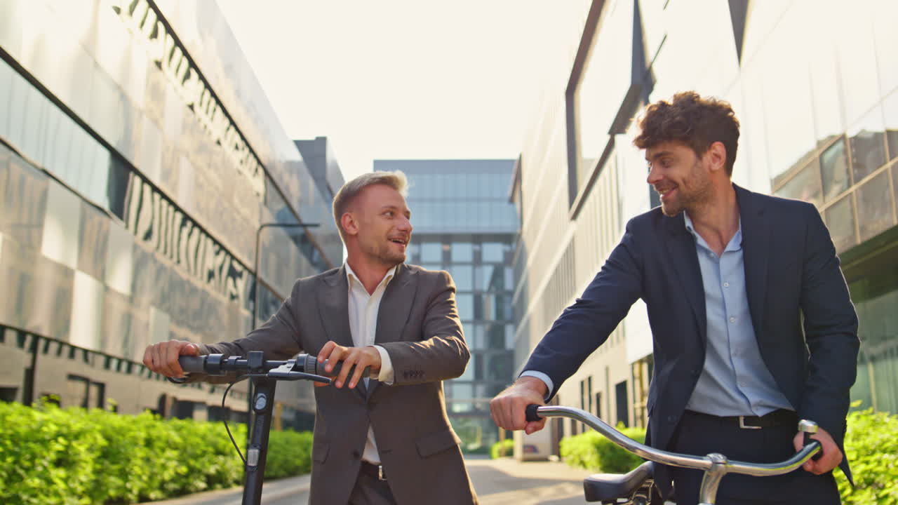 아침 빛에 시내로 가는 즐거운 동료들. 편안한 남자들이 스쿠터를 들고