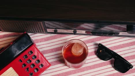 vintage retro scene with radio, phone, cocktail, and sunglasses