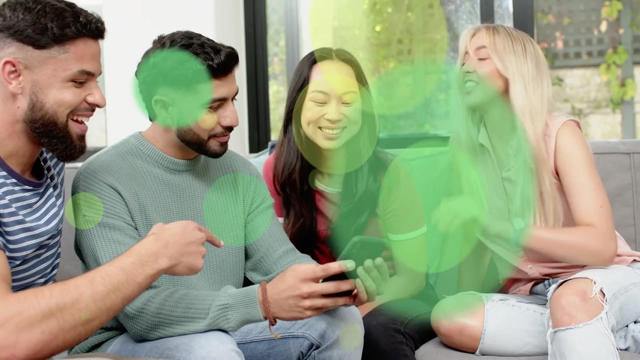 Hombre tocando el smartphone, amigos compartiendo un clip multimedia para reírse, con superposiciones verdes que ocultan al grupo.