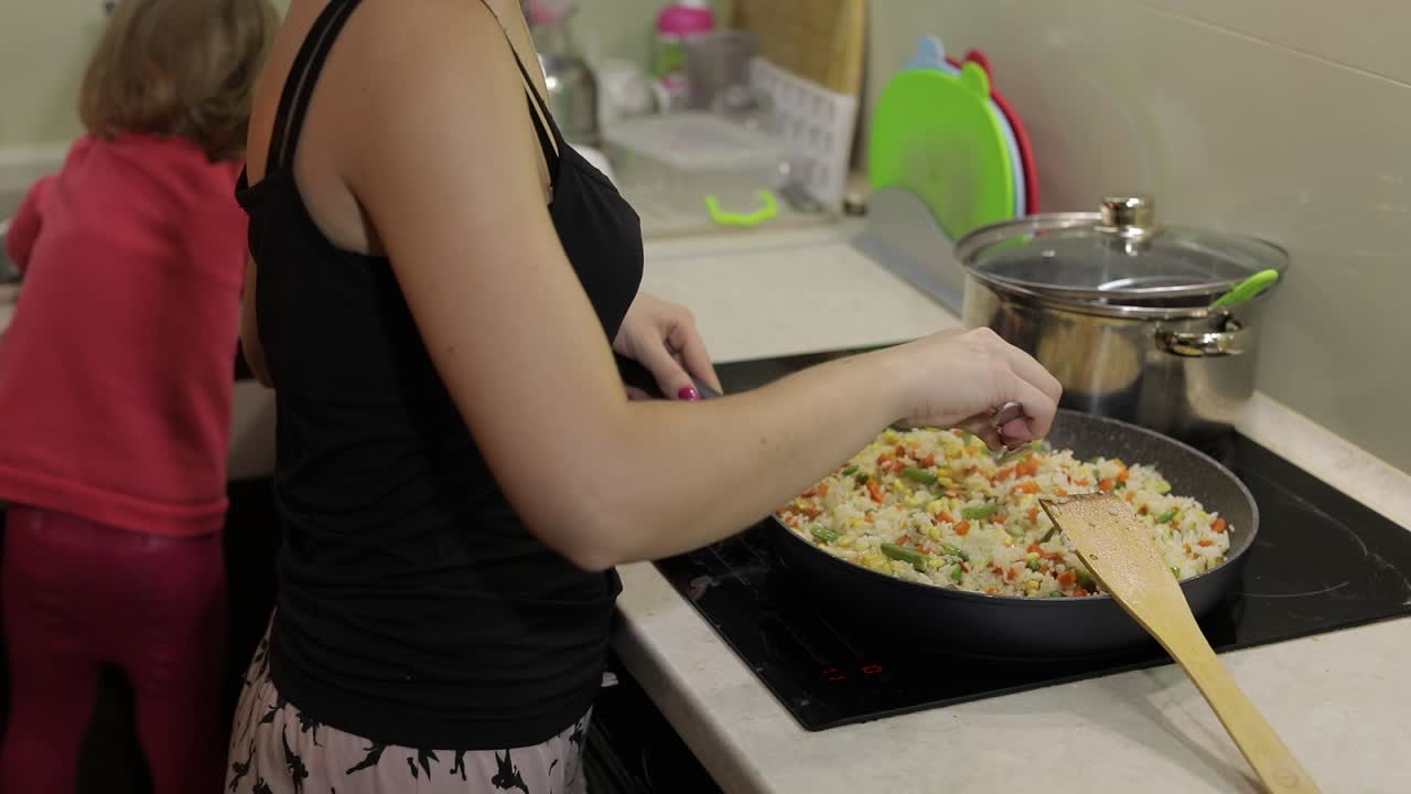 mujer cocinando comida frita. higo con espárragos, pimienta, maíz y zanahoria