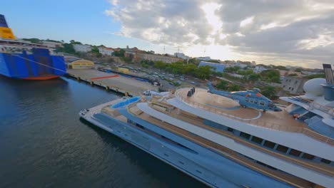 aerial fpv flight showing luxury yacht with private helicopter docking at port of don diego,dominican republic