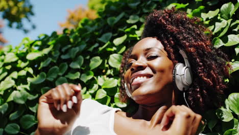 smiling woman enjoying music outdoors in nature
