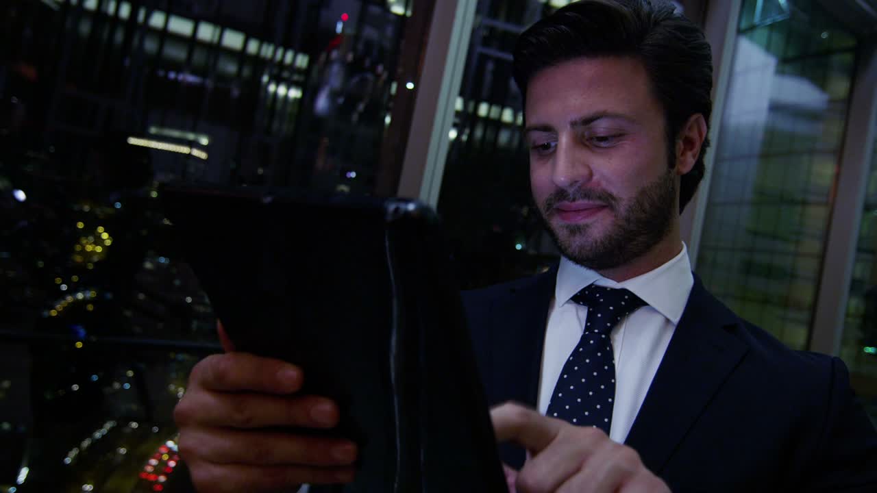 hombre de negocios árabe hotel atrium noche usando dispositivo de tableta