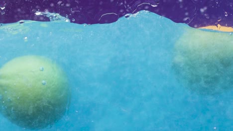 limas y limones en salpicaduras de agua