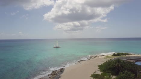 Drone-Acercándose-A-Un-Pequeño-Velero-Aislado-En-Una-Tranquila-Playa-Tropical-Paradisíaca-Agua-De-Mar-Caribeño-En-Las-Islas-De-Sotavento-De-Saint-Martin