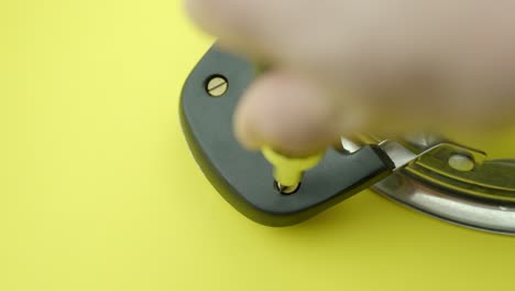 technician uses a screwdriver to unscrew boiler panel screws against a yellow backdrop.