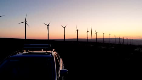 cinematic sunset footage of a car in front of windmills in eastern washington